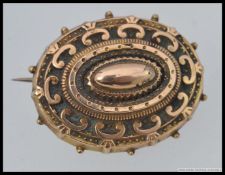 A Victorian 9ct gold ( tested / unmarked ) ladies oval brooch. Rococo form with scrollwork.