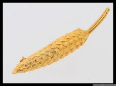 A vintage yellow metal brooch stylized in the shape of an ear of wheat / corn. Length 6.5cms.