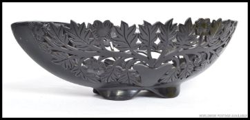 A large decorative Ebony fruit bowl, having fret pierced sides of decorative detailed foliage.