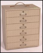 A 1950's vinyl upholstered table top stationary chest with orginal handle over bank of drawers