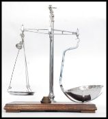 An early 20th century chrome and wooden plinth mounted pair of snuff scales by Avery.