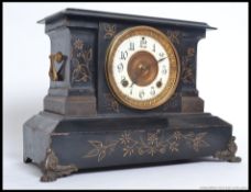 An Ansonia black metal mantel clock striking on a gong having decorative facia.