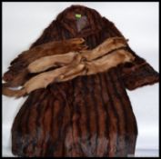 A vintage full length fur coat along with three vintage fur stoles with tails and feet attached