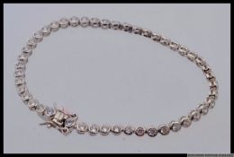 A 925 silver designer CZ set tennis bracelet. Length 17cms. Weight 8g.