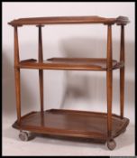 A vintage retro Ercol tea trolley, twin tiers with raised gallery sides on 4x castors.