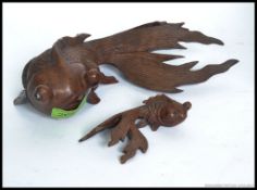 Two vintage carved wooden Chinese figures of fish, one large, one small. Both with inset glass eyes.