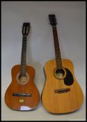 A six string acoustic guitar Encore by along with a three quarter sized six string acoustic guitar