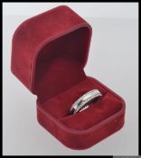 A 925 silver eternity ring with twin bands of channel set CZ within a red velvet presentation box.