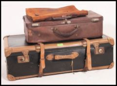 A vintage mid century leather strapped suitcase along with a leather example and vintage leather