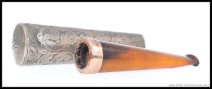 A 9ct gold rim cheroot in silver hallmarked rococo chased cheroot holder of tapered form,