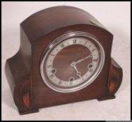 A 1940's oak cased mantel clock with silvered dial striking on a chime.