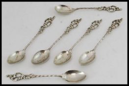 A set of 6 silver continental spoons of unusual form with decorative handles and twist stems.