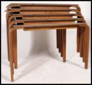 A stack of vintage school tables raised on ply bentwood frames with formica tops above