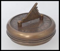 A vintage style brass cased sundial and compass.