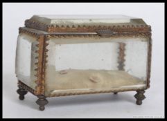 A 20th century bevelled glass casket having gilt metal rococo mount frame being raised on finial