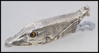 A large silver plated clip in the form of a fish with inset glass eyes.