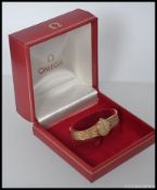 A 9ct gold original Omega ladies wristwatch with baton numerals and decorative bracelet strap