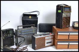 A collection of vintage and retro cassette players along with two teak effect cassette tape boxes
