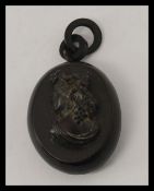A Victorian Whitby jet locket carved in high relief with a bust portrait of a lady complete with
