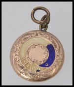 A 9ct gold and enamel set ladies pendant hair locket. Of foliate form with enamel buckle.