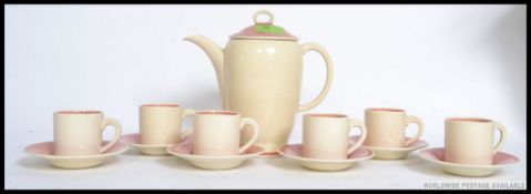 An early 20th century Susie Cooper coffee service in the Kestrel shape to include six coffee cans,