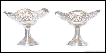 A pair of hallmarked silver bon bon dishes, raised on fluted stems with pierced bowls to top.