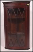 A Georgian style mahogany hanging corner cabinet with astragal glazed door and shelved interior