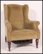 A Victorian mahogany wing back chesterfield armchair with turned legs and castors upholstered in