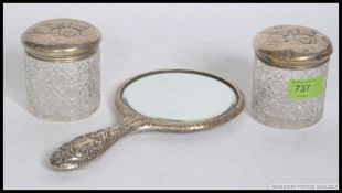 A pair of matching Edwardian dressing table cut glass silver hallmarked lidded pots with matching