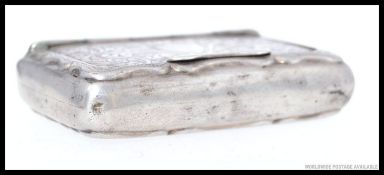 A silver hallmarked stamp box, rococo chased with plain cartouche to centre.