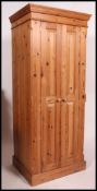 A contemporary pine two door wardrobe. The wardrobe with hanging space within.
