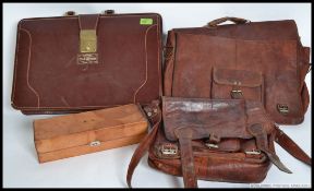 A collection of leather attache cases to include a Champion spark plugs attache.
