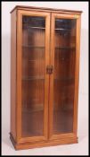 A contemporary mahogany twin door glass display cabinet.