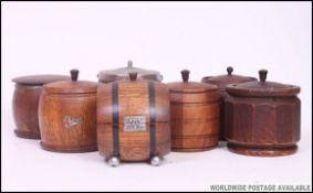 A collection of solid oak biscuit barrels and caddies from the early to mid 20th century.