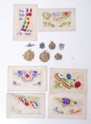 A group of seven WWI silk postcards along with a pair of brass RAF cap badges,