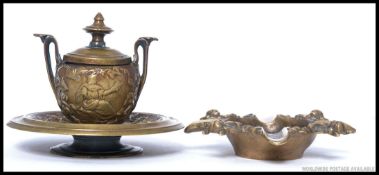 A Victorian brass inkwell in the form of