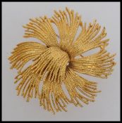 A large vintage yellow metal brooch in a