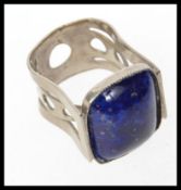 A vintage white metal ring set with a la