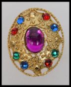 A vintage yellow metal brooch with glass