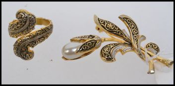 A yellow metal ring and brooch  with bla