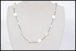 A white metal necklace set with baroque