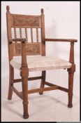 A 1920's oak Jacobean revival carver armchair of large form with drop in seats