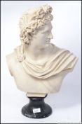 An early 20th century large parian style white bust on a vained marble socle plinth of Apollo.