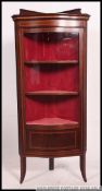An excellent Edwardian mahogany inlaid serpentine fronted corner display cabinet being raised on