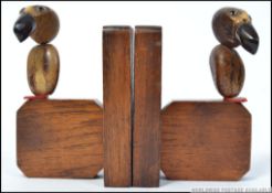 A pair of mid century oak grotesque bird bookends. Made of oak with bone beaks and bakelite feet.