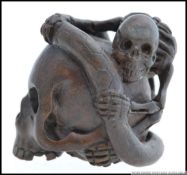 An unusual bronze figure of an intertwined skull. The weight is 202g and it is 4cm tall.