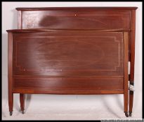 An Edwardian mahogany inlaid bow front double bed complete with the rails ( not showing ) Matching
