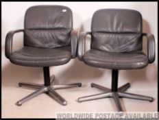 A pair of Herman Miller style modernist chrome and leather swivel office chairs upholstered in grey