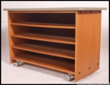 A vintage school trolley raised on castors having 4 open storage compartments