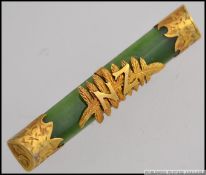 A stunning ladies Jade bar brooch being mounted with 9ct gold having the New Zealand fern with